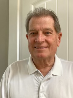 Older white male with white button-up shirt smiling